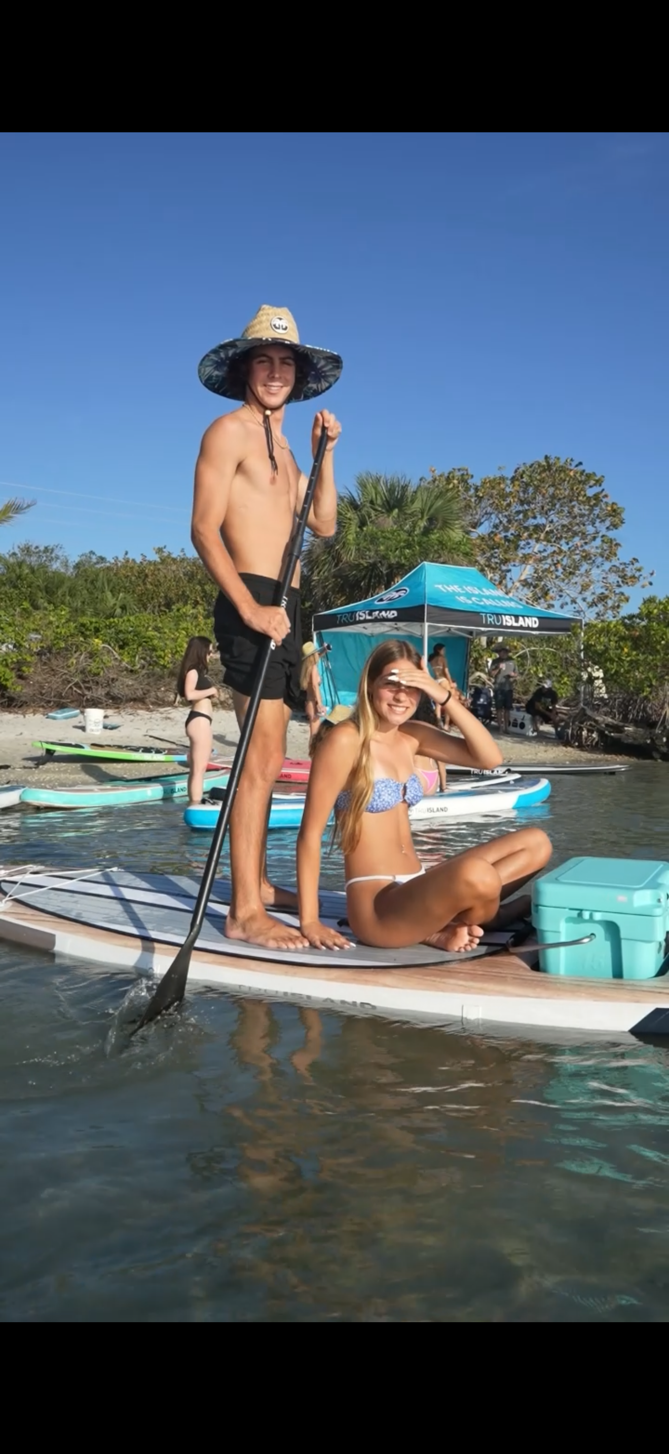 Original clear-window paddleboard in use with cooler on the nose and TruIsland tent behind